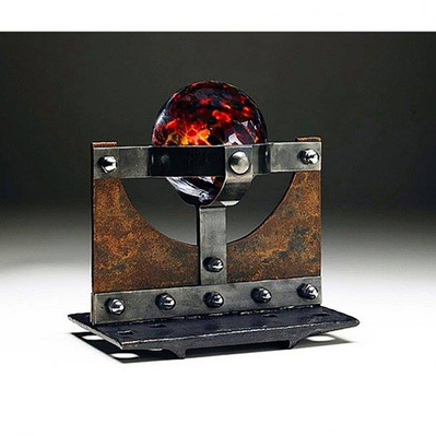 A steel sculpture with a blown glass globe held by steel bands