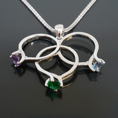 This elegant white gold three-ring pendant features vibrant Amethyst, Emerald, and Blue Topaz gemstones. A stunning piece that blends color and sophistication, perfect for adding a touch of luxury to any outfit or as a thoughtful gift for any occasion.