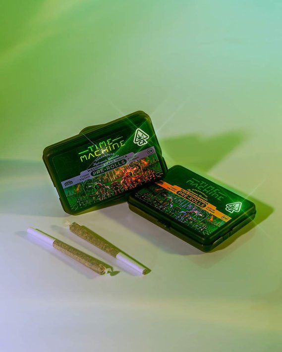 Time Machine Brand Cannabis Pre Roll Brand Photography of two joints next to two boxes of the packaging on a green gradient background with reflections and lens flare and holographic brand sticker with illustrations