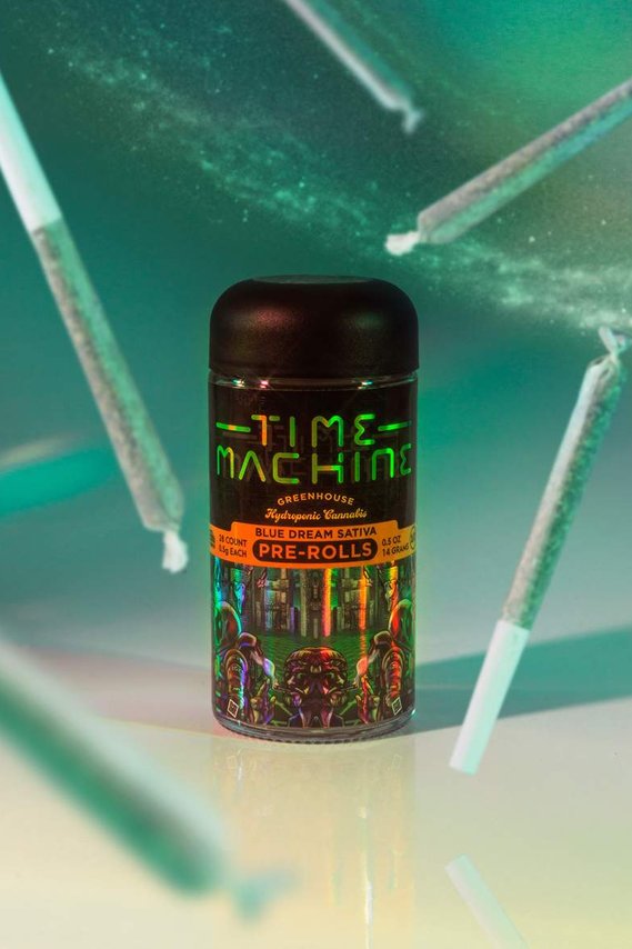 Time Machine Brand Cannabis Pre Rolls Packaging on reflective surface with celestial star space background in a teal green blue color palette with joints flying in the air around the product