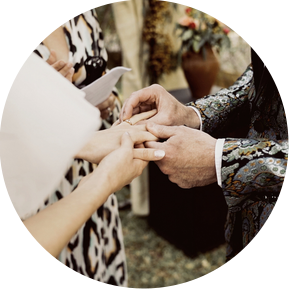 Colored photograph of a couple putting on the rings.