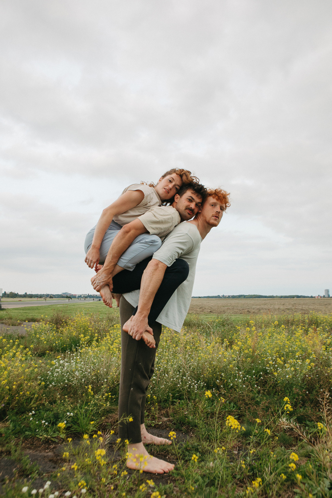 A man holds two other people on his back. Circus performers performing a movement