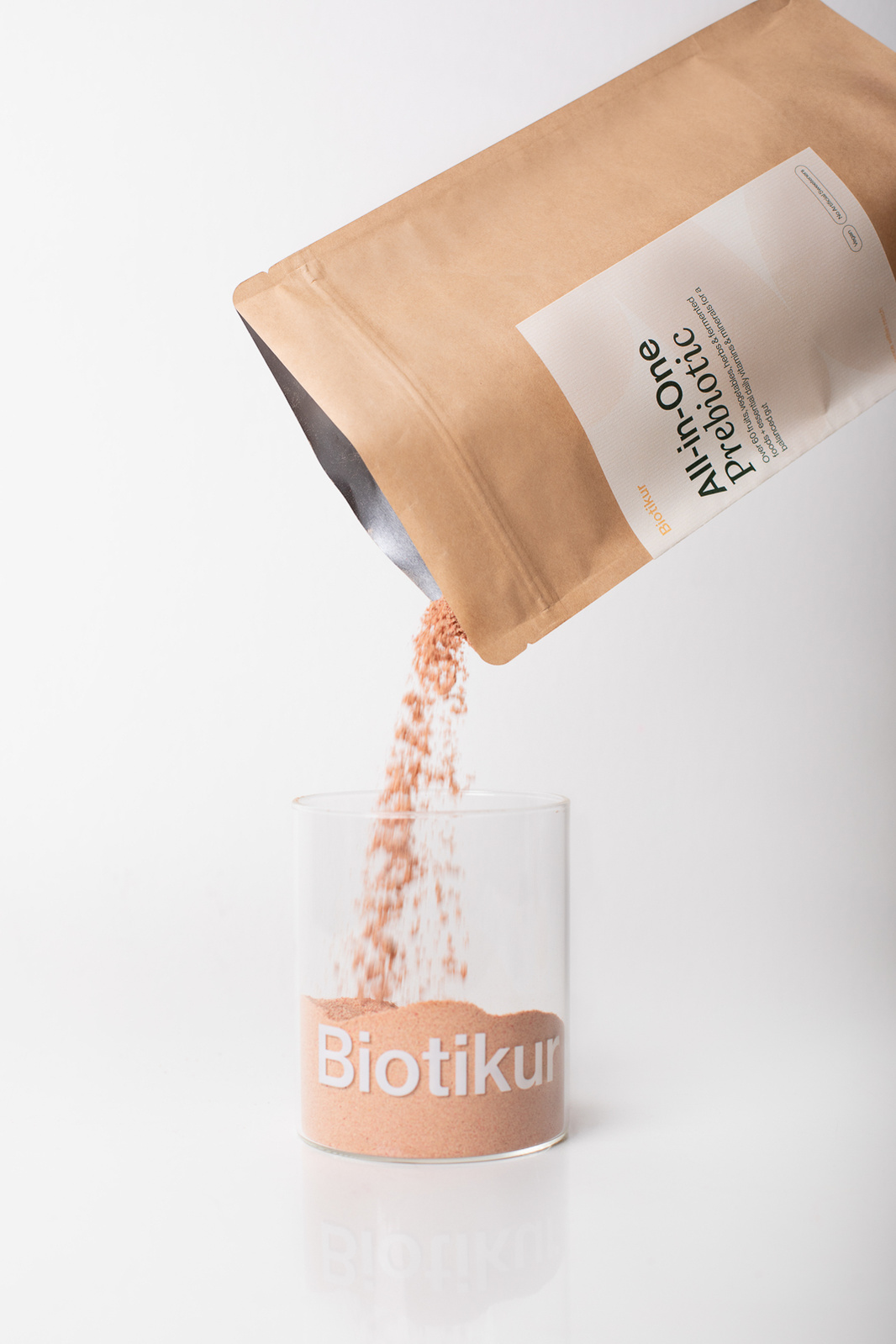 bag pouring powder into a glass container