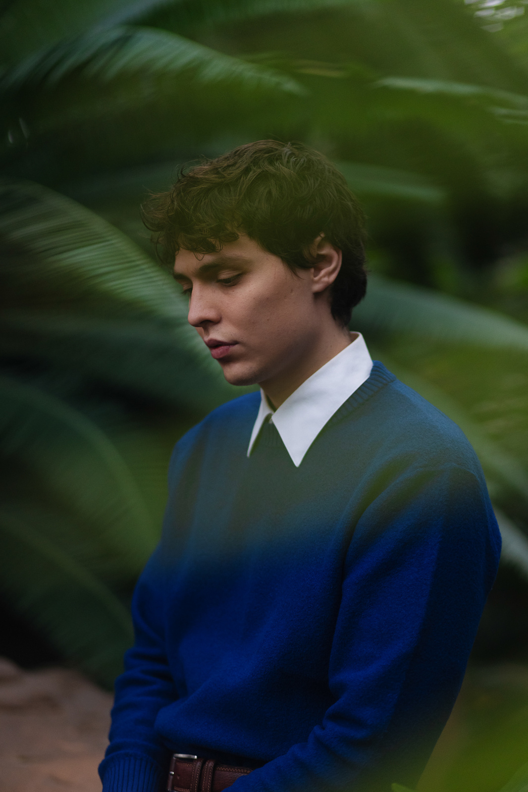 A man in a blue coat in a botanical garden