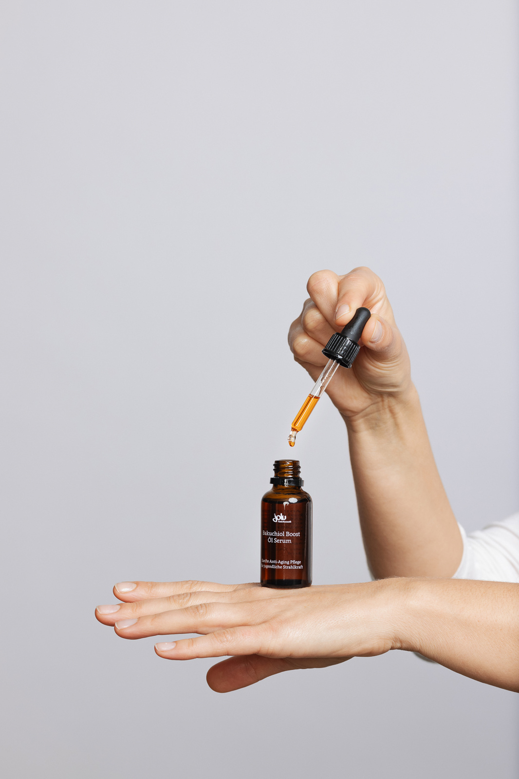 hands holding face oil