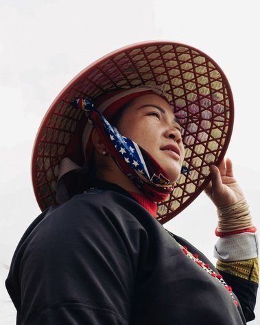 A woman in a Vietnamese hat looking at the horizon.
