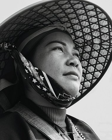 close up of woman in black and white photo wearing a Vietnamese hat