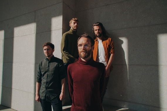 four men posing in the sunlight