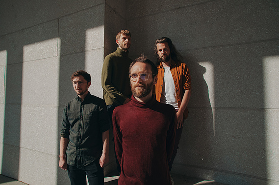 four men posing in the sunlight