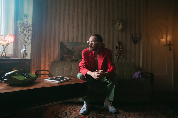 man with glasses sitting on a sofa with smoke around him 