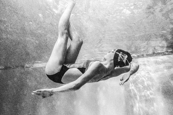 woman dancing underwater in her bathing suit