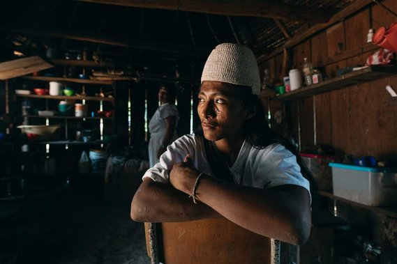 indigenous man looks to the left through window