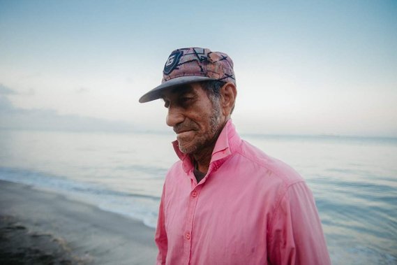 fisherman in front of the sea with pink t-shirt