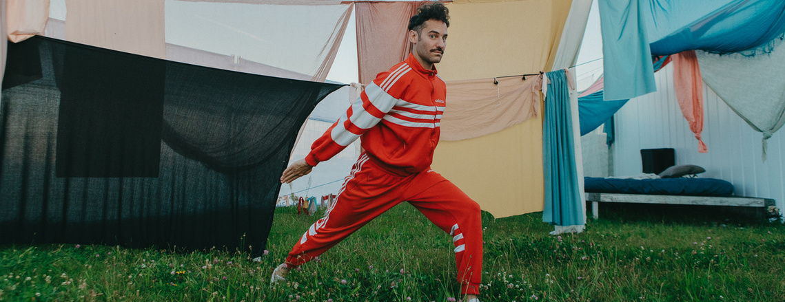 man dressed in red in front of a clothesline