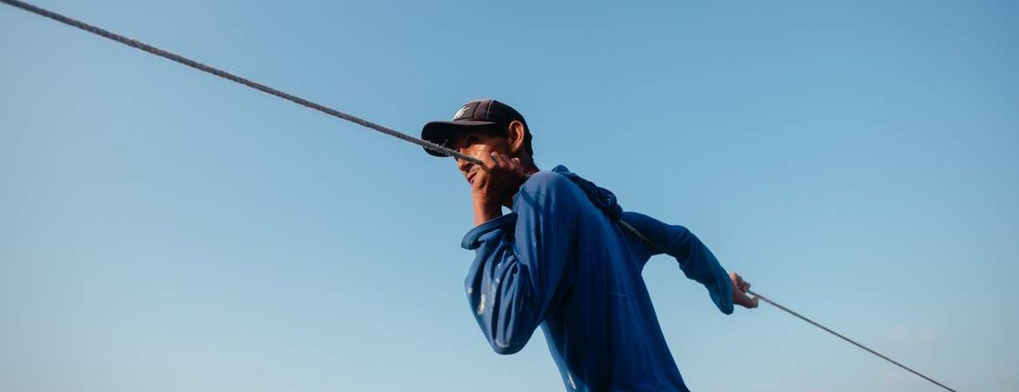 fisherman pulling the net with a sky background