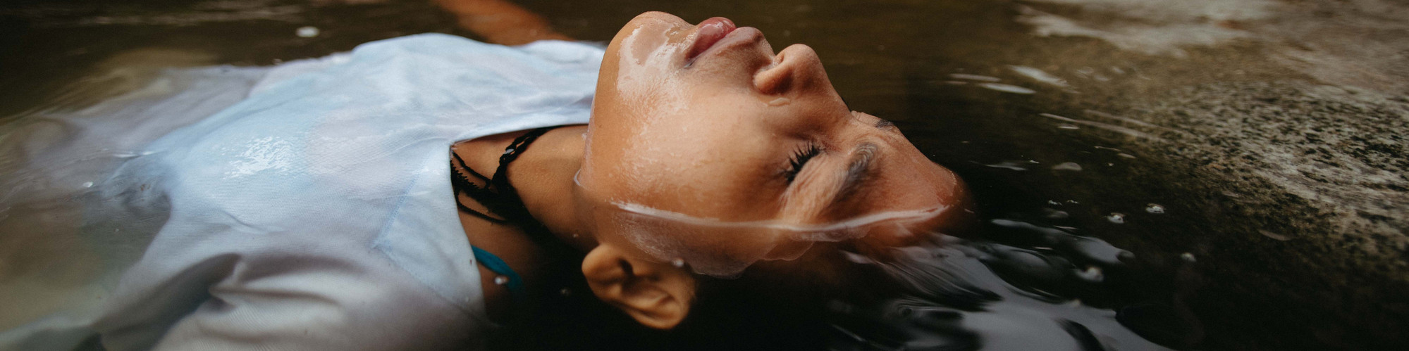indigenous girl swimming on her back in a river