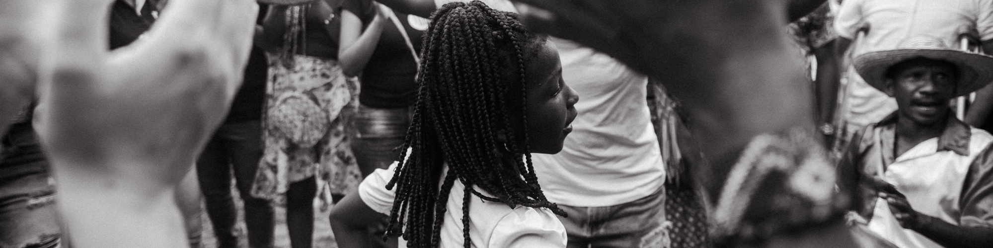 afro girl dancing in the middle of a circle with people playing instruments 