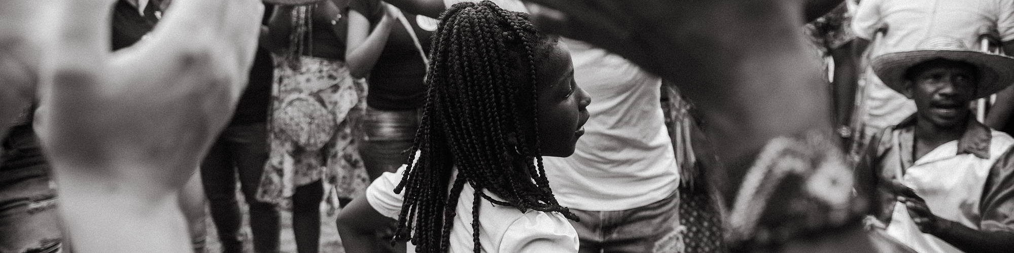 afro girl dancing in the middle of a circle with people playing instruments 