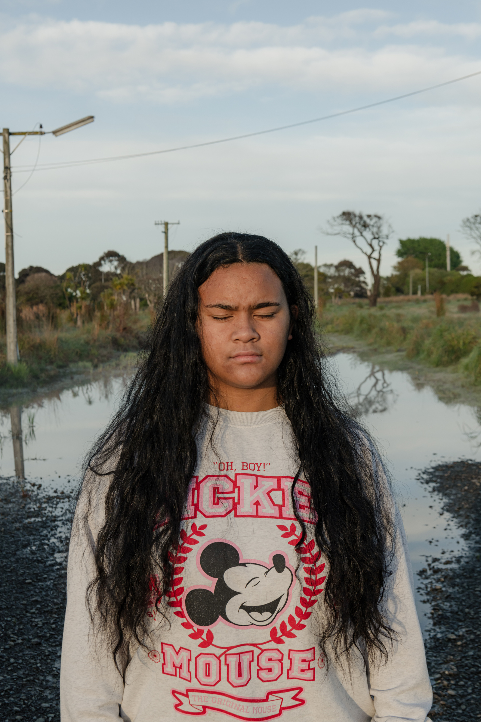 Sue (Sara) Saumanaia, 15, poses for a portrait standing on a former residential street in Bexley that became uninhabitable after earthquake damage, dropping nearly a meter in Christchurch, New Zealand, on Saturday morning, October 12, 2024. Bexley is not