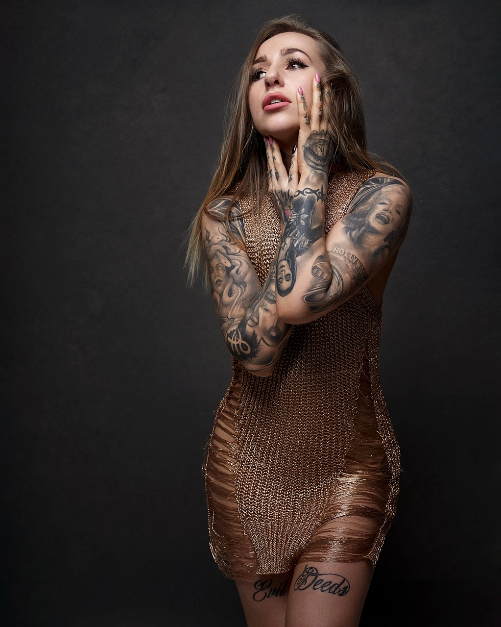Tattooed model girl wearing gold short dress on black background blonde hair and red lipstick photographed at Aire Street Studio & Headshots Leeds