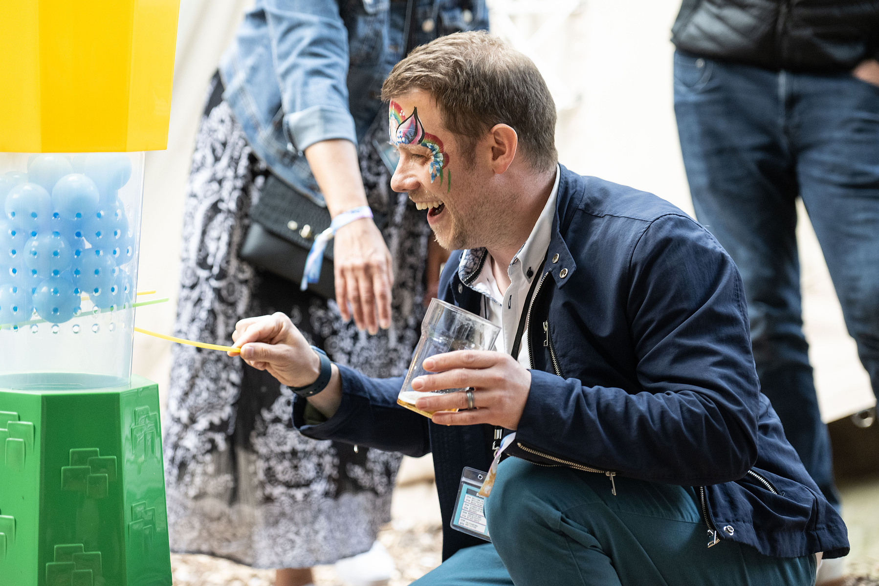 Man playing kerplunk at a festival in suit at a team building day photographed by Mark Wheelwright from Aire Street Studios Leeds