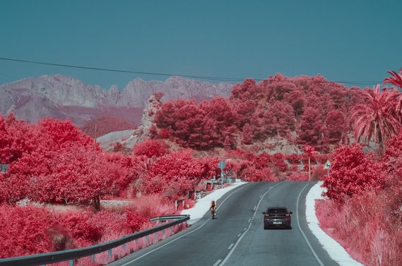 A car and a biker on a mountain road in Spain