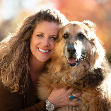 Happy photographer posing with her dog with fall colors.
