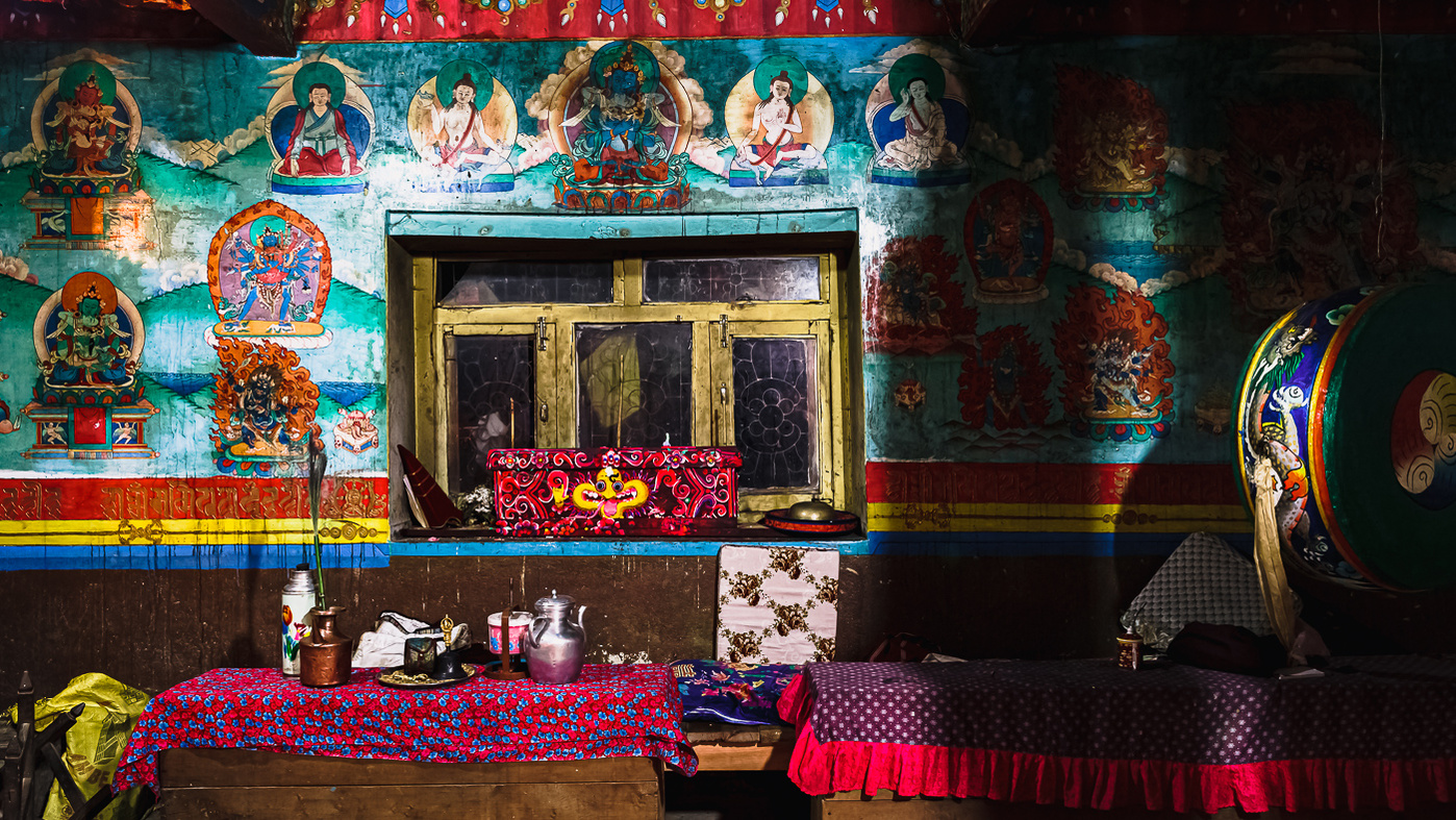 peinture bouddhiste sur un mur à l'intérieur d'un temple avec paillasse rose et objets de culte