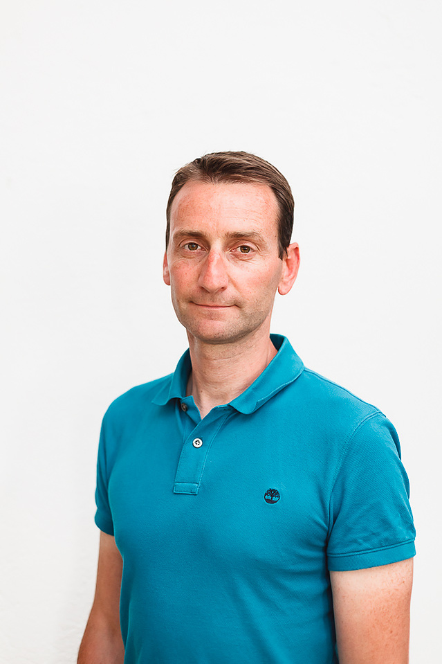 portrait sur fond blanc d'un jeune homme bien coiffé au polo bleu