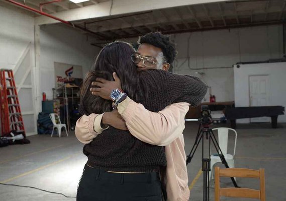 Man passionately embraces a woman on the set of {THE AND}
