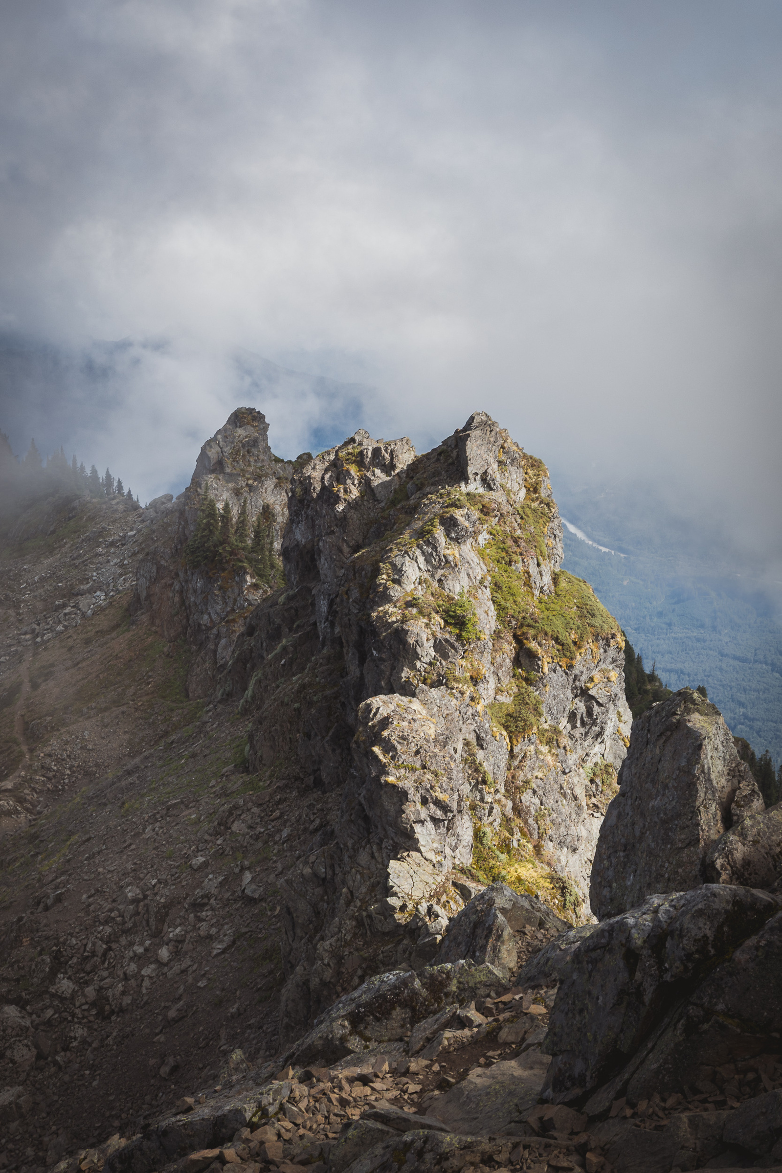 Jagged rocky ridge emerging through mist and low clouds in the Cascade Mountains of Washington.