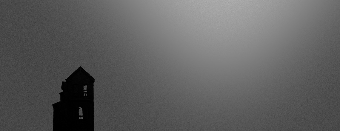 A house silhouette standing alone in a cloudy/grey background