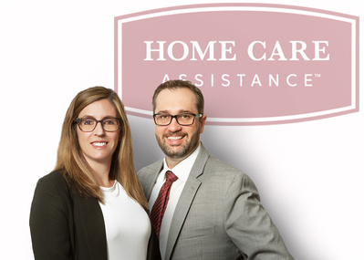Two adults in a portrait headshot  with business logo behind on white background