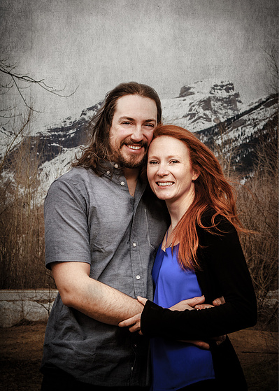 An environmental portrait of a young coule embracing and smiling.