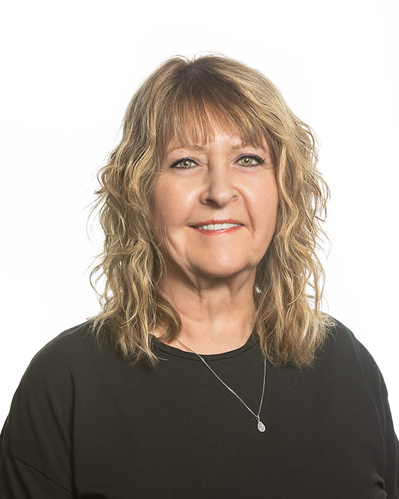 A headshot portrait of a blonde hair lady wearing a black top on a white background.