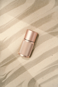 Life Long Deo X Scott Uzoho -- product still-life photography of sustainable deodorant on a sandy beach with sun light beam and shadow 