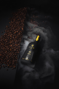 Vivir Coffee X Scott Uzoho -- product still-life photography of tequila bottle on a bed of coffee beans and smoke smothering the scene 