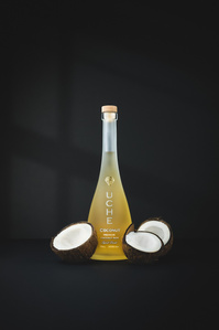 Uche Rum X Scott Uzoho -- product still-life photography of coconut rum with a base of open cracked coconuts on a black background and shadow 