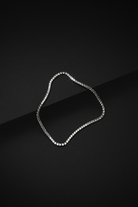 Ventr X Scott Uzoho -- product still-life photography of a silver tennis necklace perched on 2 black slates 