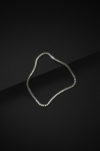Ventr X Scott Uzoho -- product still-life photography of a silver tennis necklace perched on 2 black slates 