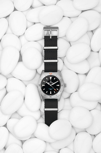Belhamel X Scott Uzoho -- product still-life photography of swiss watch panically covered over sand with horizontal line pattern