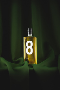 8 Rivers Rum X Scott Uzoho -- product still-life photography of with light glowing through bottle infront of emerald green curtain 