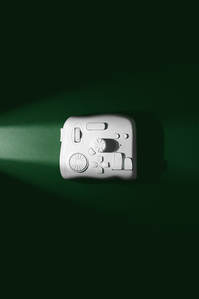 Tourbox X Scott Uzoho -- product still-life photography of editing tool on emerald green light beam background flatlay 