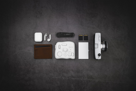 Tourbox X Scott Uzoho -- product still-life photography of editing, camera, canon cannot, leather bullstrap, AirPods apple and memory sd cards in a everyday carry style flatlay 