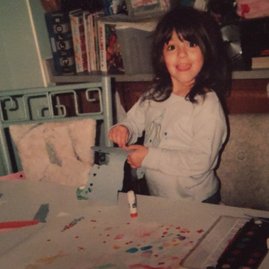 pictured: an image of Erica around the age of 4. She is making art. 