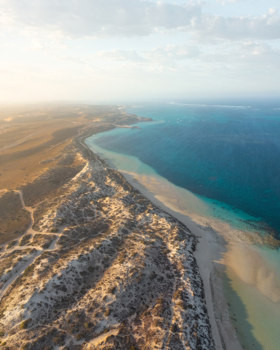 Dappled light across sand dunes by the beach in Coral Bay.