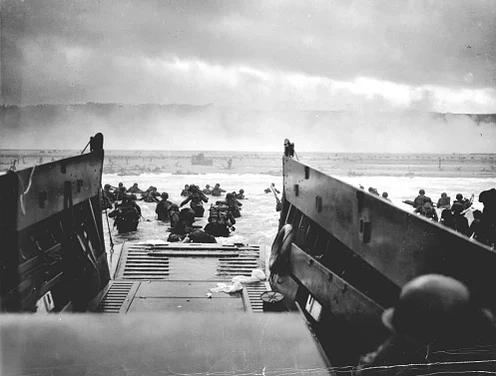 La legendaria imagen de Robert Capa del Desembarco de Normandía captura la escena caótica y valiente de los soldados aliados desembarcando en las playas el 6 de junio de 1944, un momento crucial en la Segunda Guerra Mundial.