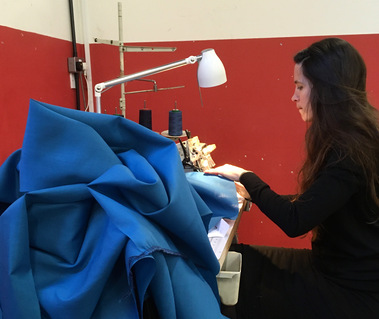 A mound of garment pieces are being overlocked with industrial overlocking machines loaned to us by K-Sewing Machines.