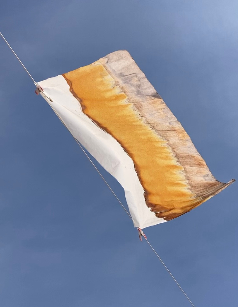 Chromatograph on delicate paper flying high against the sky.