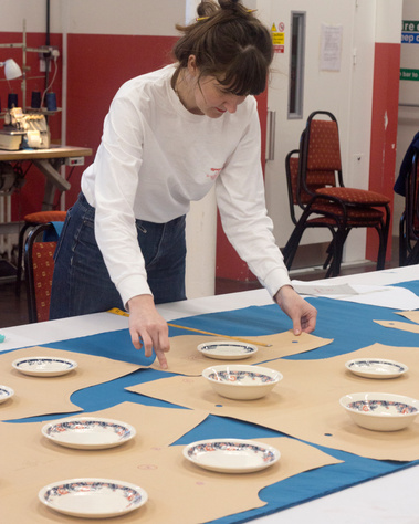 Pattern pieces are being laid out to precision for marking and cutting the fabric.